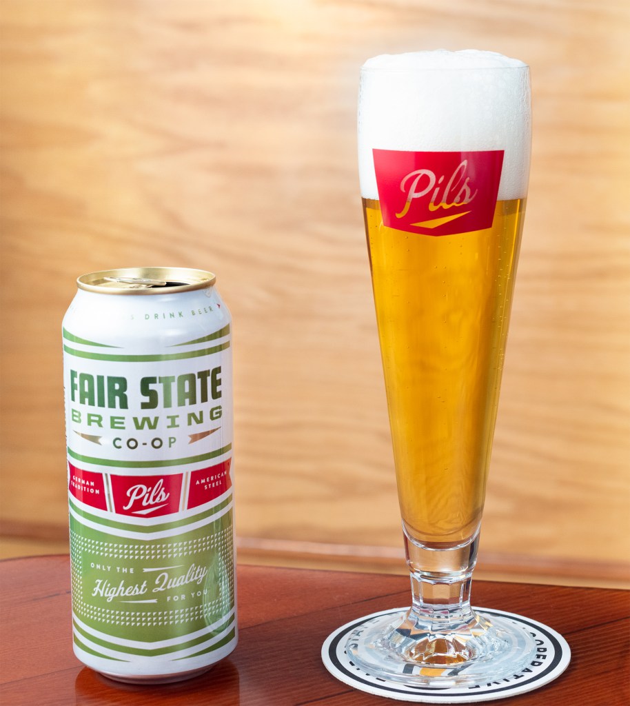 Fair State Pils can with a full pilsner glass next to it