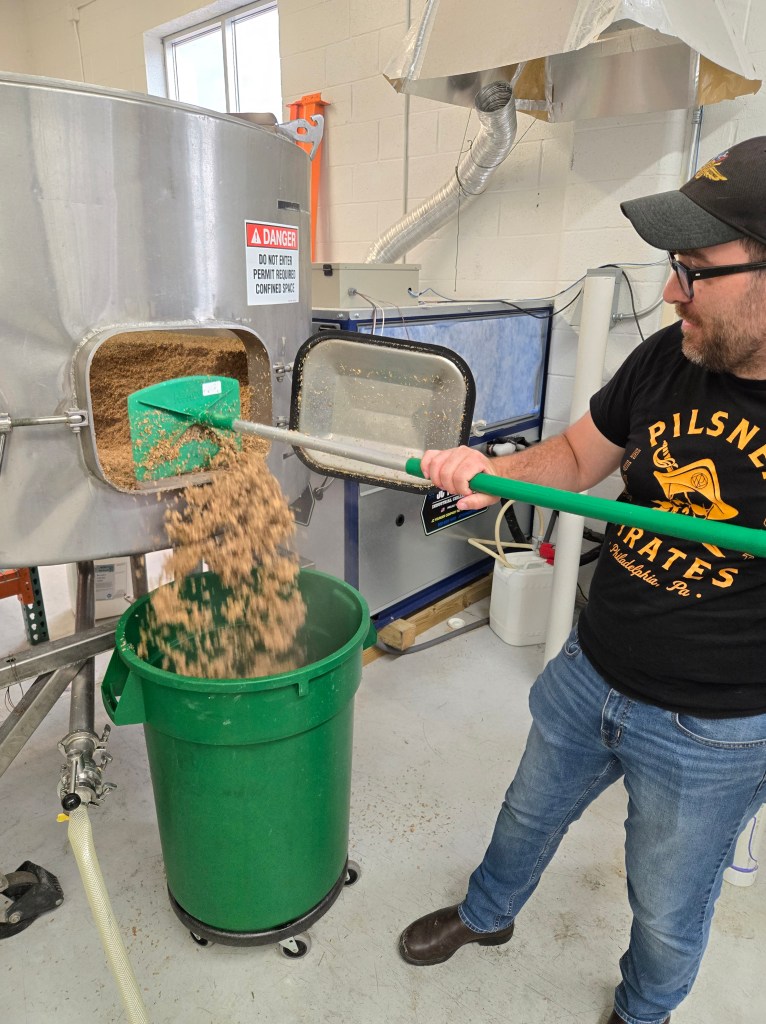 James Figy empties spent grain at Haggard Barrel